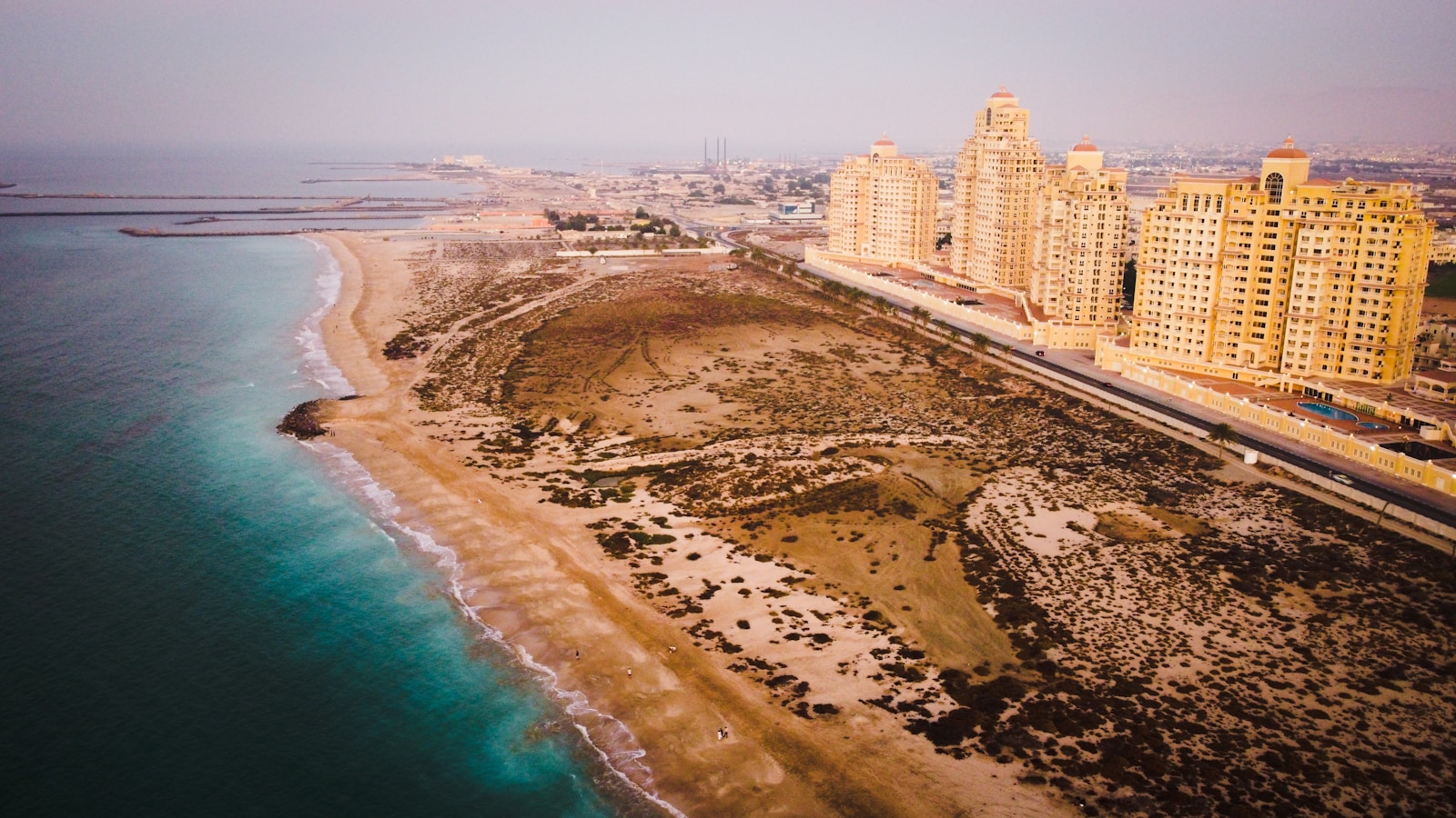 Photo by Marvin Castelino aerial view of city buildings near body of water during daytime